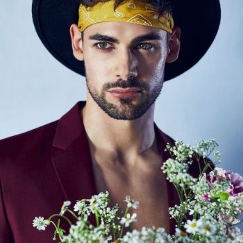men fashion editorial, Foto von Mann mit Hut und Stirnband mit blumenstrauß