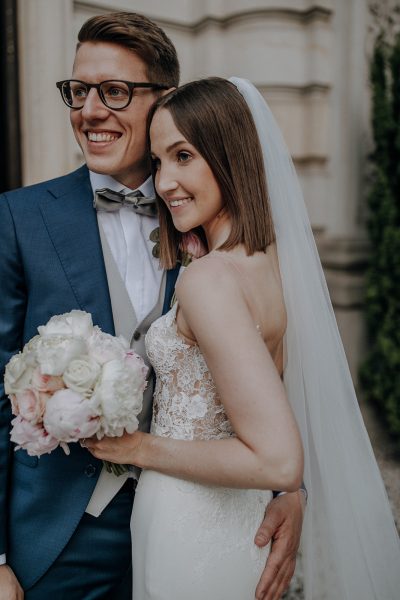 straight and naturally, Bild von einem Brautpaar, die Braut ist wunderschön zart geschminkt und hat glatte Haare mit einem Schleier